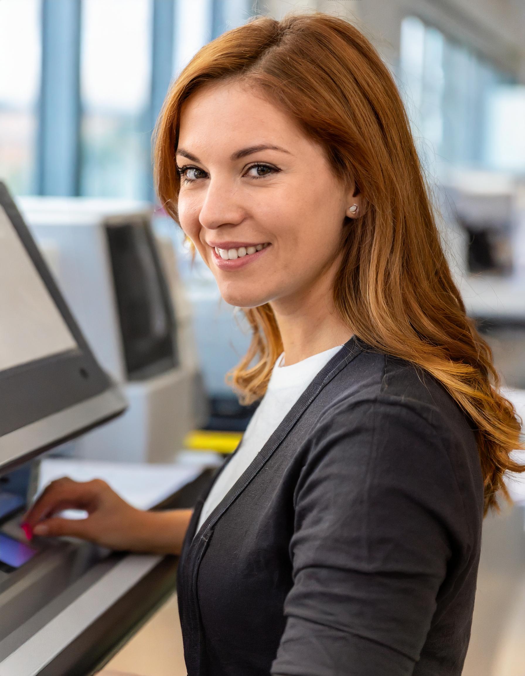 Porträt einer Frau, die freundlich in die Kamera lächelt, im Büro.